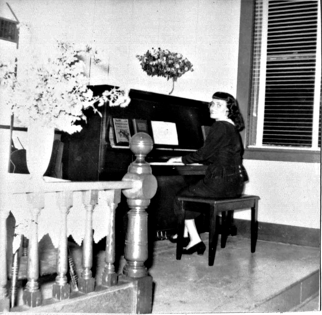 Mom looking toward the camera as she plays the piano in church